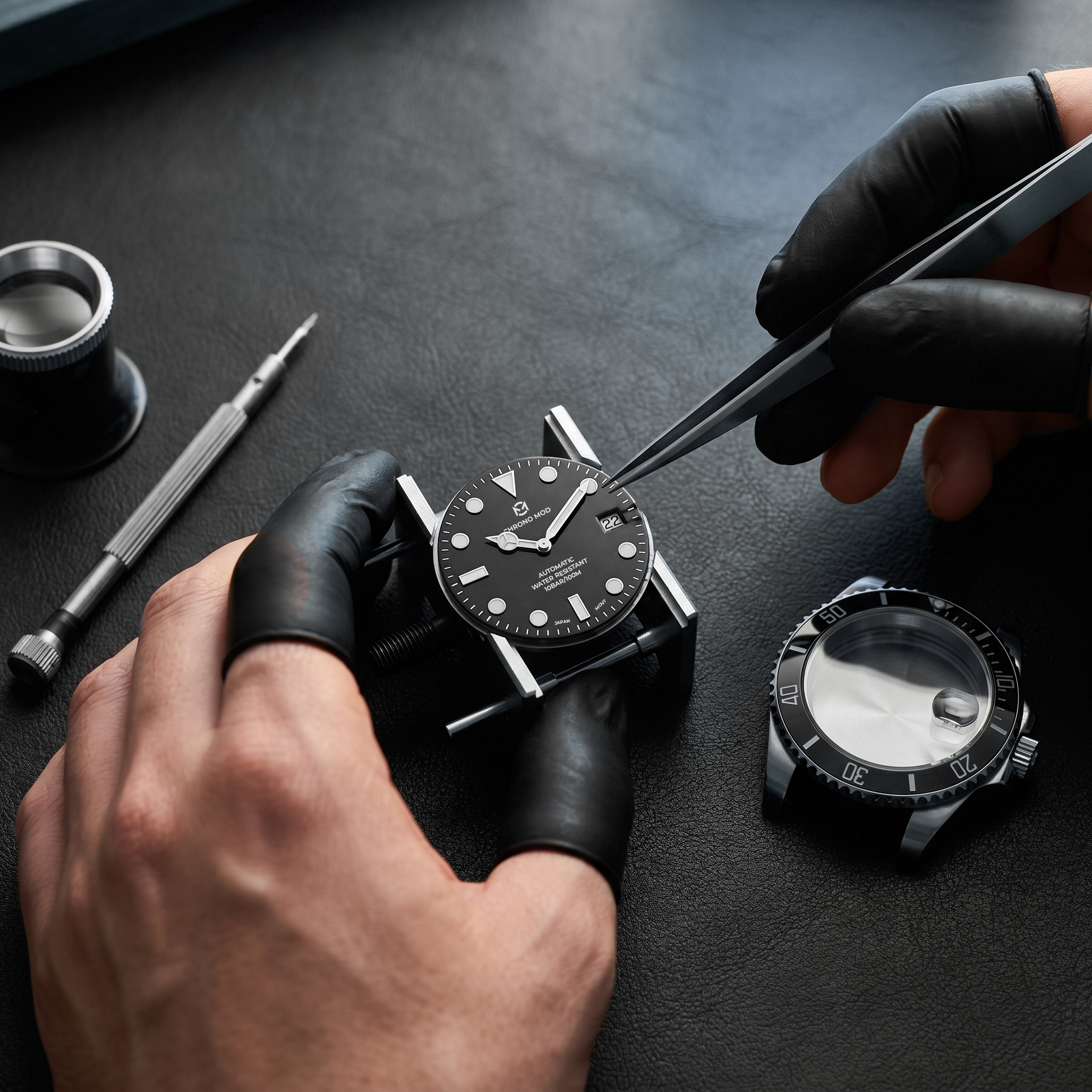 Hand assembly of a black Chrono Mod submariner on black leather